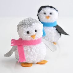 two small white and black penguins with pink scarves