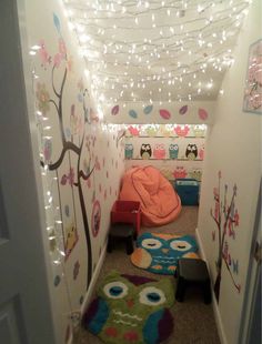 the hallway is decorated with lights and owls on the wall, while a child's bed sits in the corner