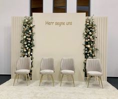 two white chairs sitting next to each other on top of a carpeted floor in front of a wall