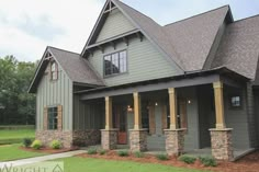 a large gray house with stone pillars and windows