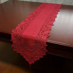 a red table runner sitting on top of a wooden table next to a brown table