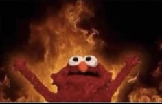 the sesame street character is standing in front of a fire with his arms out and eyes wide open