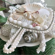 shells and seashells are arranged on a platter with pearls, starfish