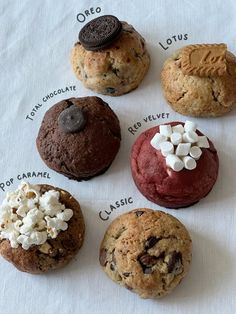 chocolate chip cookies, oreo cookies, and marshmallows are arranged on a white tablecloth