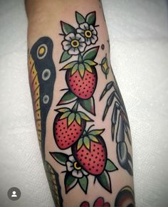 a tattoo with strawberries and flowers on the arm, next to a pair of scissors