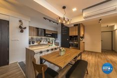 an open kitchen and dining area with wooden floors, white walls, and black appliances