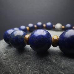 Introducing our Men's Lapis Lazuli Beaded Bracelet, a harmonious blend of style and spirituality. This gemstone bracelet, meticulously crafted with natural Lapis Lazuli beads, exudes a minimalist charm that effortlessly complements any ensemble. The 925 Sterling Silver detailing adds a touch of sophistication, making it a versatile accessory for any occasion. Designed for both style and strength, this stretch bracelet features Yellow Tiger Eye gemstones, renowned for their grounding properties. Natural Lapis Lazuli Bracelets, Polished Beads Lapis Lazuli Round Bracelets, Polished Beads Lapis Lazuli Bracelets, Round Lapis Lazuli Bracelets With Polished Beads, Bracelet Mens, Lapis Lazuli Stone, Tiger Eye Beads, Mens Beaded Bracelets, Tiger Eye Stone