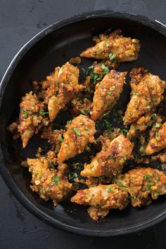 chicken wings in a skillet with parsley on top