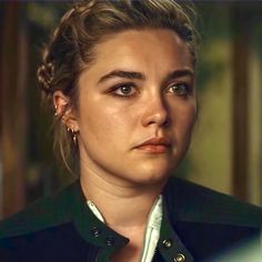 a close up of a person wearing a black jacket and white shirt with braids