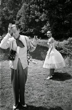 a man standing in the grass next to a woman