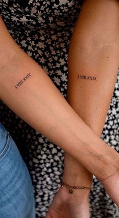 two people holding hands with the word love written on their arm and one is holding the other's hand