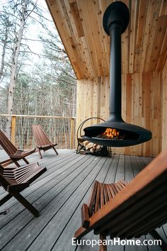 a wood deck with chairs and an outdoor fireplace