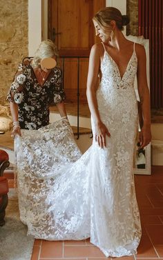 a woman in a white dress standing next to another woman