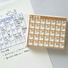 a rubber stamp sitting on top of a piece of paper next to a printable calendar