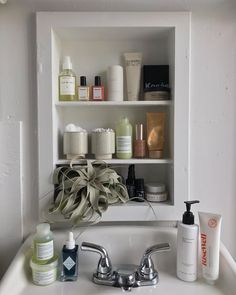 a bathroom sink filled with lots of different types of soaps and lotion bottles