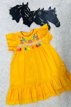 Dress features with floral embroidery on yellow background with pompoms tassels. Spandex & Polyester fabric Including: Dress only Festive Yellow Dresses With Floral Embroidery, Festive Yellow Ruffled Dress, Festive Yellow Short Sleeve Dress, Yellow Cotton Dress With Floral Embroidery, Yellow Bohemian Dress With Floral Embroidery, Traditional Yellow Embroidered Cotton Dress, Yellow Bohemian Dress With Tassels, Yellow Embroidered Summer Dress, Yellow Embroidered Dress With Short Sleeves For Summer