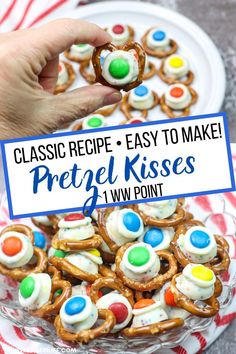 a person is holding up a sign that says, classic recipe - easy to make hershey kiss pretzels with m & ms's