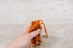 a person holding an orange string in their hand