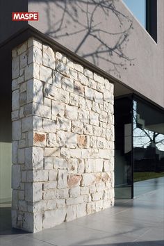 a stone building with a tree shadow on it