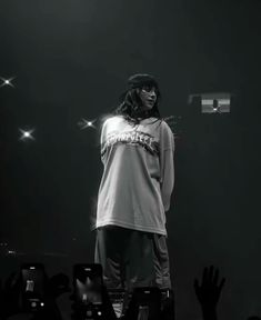 a man standing on top of a stage with his hands up in front of him