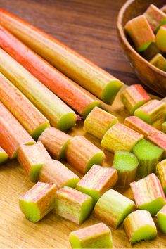 chopped rhubarb on a cutting board next to a bowl of rhubars