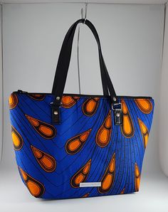 "\"Bag description:  This lovely bag is a perfect size for any occasion, with ample room for all your essentials when shopping or going to the office. The peacock design in blue and orange can be dressed up setting the mood for an evening out. This tote bag is a combination of Ankara African fabric and faux leather, fully lined waterproof canvas fabrics. The handles are long enough to fit comfortably on the shoulder or held by hand. Internally, this bag is fully lined with waterproof canvas and zippered pocket which fits your phone or other valuables. This bag is closed with a durable zip. Bag Style: Tote Fabric: African Wax Print Fabric - Ankara blue and orange print fabric. 100% Cotton Lining: Waterproof canvas Hardware: Chrome  Handles: 24 inches in black faux leather Bottom: 12 x 4 inc Blue Rectangular Shoulder Bag With Large Capacity, Large Capacity Blue Rectangular Shoulder Bag, Blue Large Capacity Pouch Bucket Bag, Large Capacity Blue Pouch Bucket Bag, Blue Large Capacity Pouch Bag, Large Capacity Blue Pouch Bag, Blue Large Capacity Tote Shoulder Bag, Blue Double Handle Bucket Bag For Daily Use, Large Capacity Blue Rectangular Bucket Bag