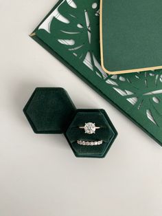 an engagement ring sits in a green velvet box