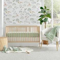 a baby's room with a crib, chair and wallpaper in pastel colors