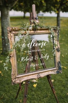 an easel with greenery on it and a sign that says welcome to the wedding