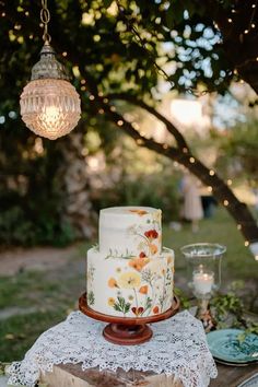 a wedding cake sitting on top of a table next to a glass vase and candle