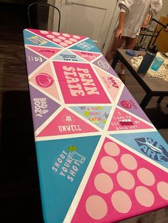 a man standing next to a table covered in pink, blue and white stickers