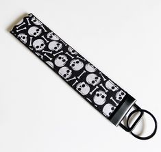 a black and white keychain with skulls on it