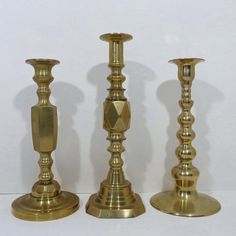 three brass candlesticks sitting next to each other