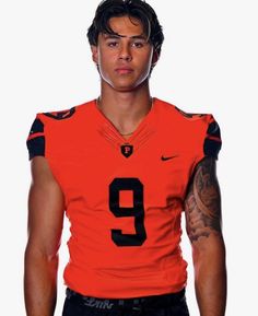 a man in an orange football uniform with tattoos on his arm and chest, posing for the camera