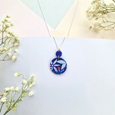 Elevate your style with our Blue Floral Circular Pendant Necklace. This unique necklace features a circular pendant meticulously handcrafted from polymer clay, showcasing a vibrant bright blue hue adorned with intricately hand-painted florals. The pendant's design includes exquisite raised detailing, including delicate leaves and tulips, adding depth and texture to this wearable work of art. Features: Design: The circular pendant boasts a captivating bright blue design with intricate hand-painted florals. Material: Crafted from polymer clay, this pendant is lightweight and durable for all-day comfort. Artisan-Made: This necklace is lovingly handmade by our small artisan team, ensuring the highest level of craftsmanship and care. Size: The circular pendant is eye-catching and adds a touch o Artisan Blue Hand Painted Necklaces, Artisan Hand Painted Blue Necklaces, Artisan Hand Painted Blue Necklace, Unique Blue Hand Painted Necklace, Blue Hand Painted Round Pendant Jewelry, Unique Hand Painted Blue Necklace, Handmade Blue Medallion Necklace, Blue Hand Painted Round Pendant Necklace, Blue Polymer Clay Pendant Jewelry