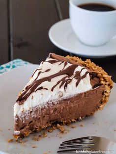 a piece of chocolate pie on a plate with a fork and cup of coffee in the background