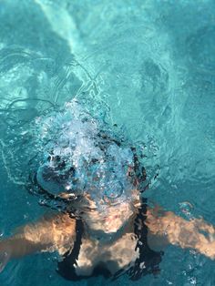 a man swimming in the water with his head above the water's surface as he swims