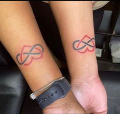 two people with matching wrist tattoos on their arms, one has an arrow and the other has a heart