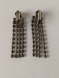 Beautiful vintage rhinestone earrings. Antiqued silver-tone setting and four dangling chains, all set with gray rhinestones. Measures 2 1/8 inches long. Clip on backs. The metal has a gray patina. Some of the rhinestones are a bit darkened. Shop Policies: Shipping: All items will be shipped through the USPS unless otherwise marked. Most items will be shipped first class. Expect shipment within 1-2 business days from date of payment. Refunds:Vintage items are all used and have varying amounts of Silver Clip-on Chandelier Earrings For Evening, Silver Chain Earrings For Evening, Silver Metal Clip-on Earrings Costume Jewelry, Silver Metal Clip-on Earrings With Rhinestones, Silver Metal Chandelier Earrings For Evening, Silver Nickel-free Chandelier Earrings For Evening, Vintage Rhinestone Earrings, Rhinestone Chain, Silver Rhinestone