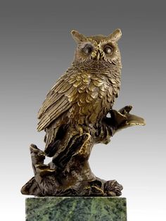 an owl statue sitting on top of a green marble base