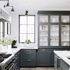 a kitchen with black cabinets and white counter tops is featured on the instagram page