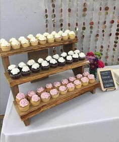 cupcakes are displayed on three tiered trays