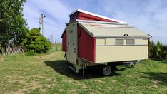 a small trailer is parked in the grass