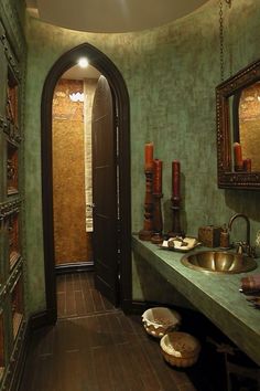 the bathroom is decorated in green and gold with candles on the wall, along with two sinks