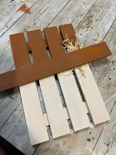 a piece of wood sitting on top of a wooden floor next to a nail file