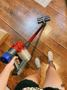 a woman is using a vacuum cleaner on the floor