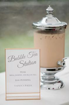 a table topped with a cup of tea next to a sign that says bubble tea station