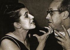 an old black and white photo of a man helping a woman put on her nose