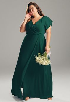 a woman in a green dress holding a bouquet