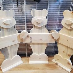 four wooden teddy bears are standing next to each other